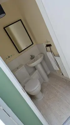 a bathroom with a sink and a toilet and a mirror at Carr Garth in Arnside