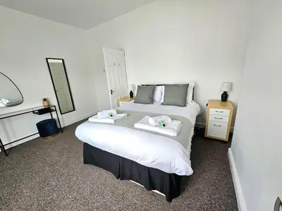 a bedroom with a large white bed with two towels at Entire house, Waterloo, free street parking in Waterloo