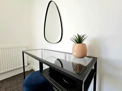 a glass table with a potted plant and a mirror at Entire house, Waterloo, free street parking in Waterloo