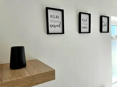 a wall with four framed pictures on a wall with a table at Entire house, Waterloo, free street parking in Waterloo