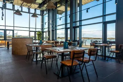 a restaurant with tables and chairs and large windows at Entire house, Waterloo, free street parking in Waterloo