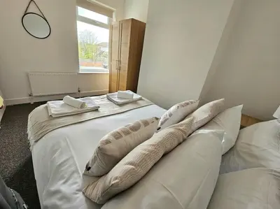 a bedroom with a large white bed with pillows at Entire house, Waterloo, free street parking in Waterloo