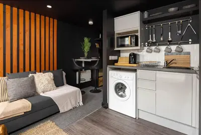 a living room with a washing machine and a kitchen at One of Kind Boutique Pad in Liverpool