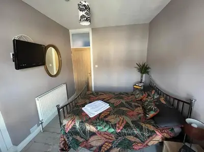 a bedroom with a bed and a tv on the wall at Charming newly renovated terrace in Liverpool