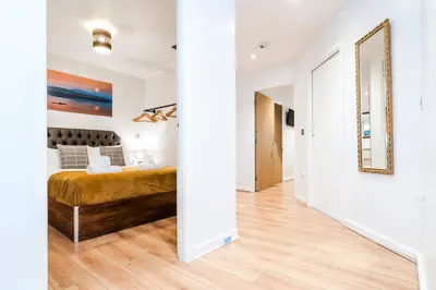a bedroom with a bed and a mirror at Cavern Quarters, Beautiful Two Bedroom City Centre Apartment by Garudy Serviced Apartments in Liverpool