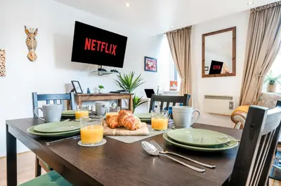 a dining room with a table with food and orange juice at Cavern Quarters, Beautiful Two Bedroom City Centre Apartment by Garudy Serviced Apartments in Liverpool