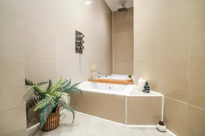 a bathroom with a tub and a plant in it at Cavern Quarters, Beautiful Two Bedroom City Centre Apartment by Garudy Serviced Apartments in Liverpool