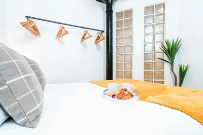 a room with a bed with a tray of food at Cavern Quarters, Beautiful Two Bedroom City Centre Apartment by Garudy Serviced Apartments in Liverpool