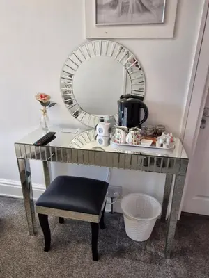 a dressing table with a mirror and a stool at Rocklea Hotel in Blackpool