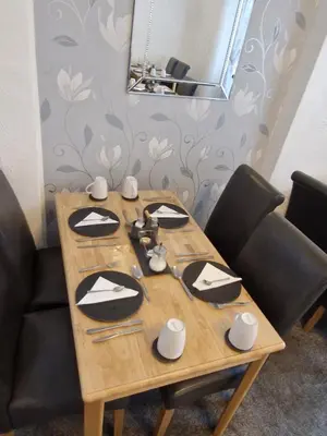 a wooden table with black and white plates on it at Rocklea Hotel in Blackpool