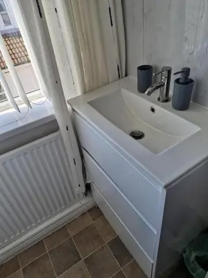 a white sink in a bathroom with a window at Rocklea Hotel in Blackpool