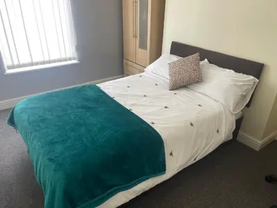 a bed with a green blanket on it in a room at Marks Place in Liverpool