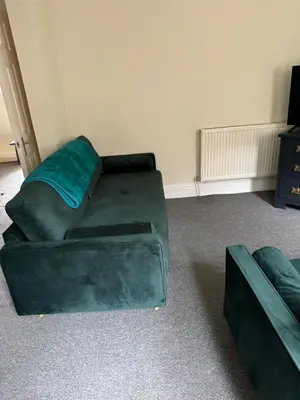 a living room with a green couch and a chair at Marks Place in Liverpool