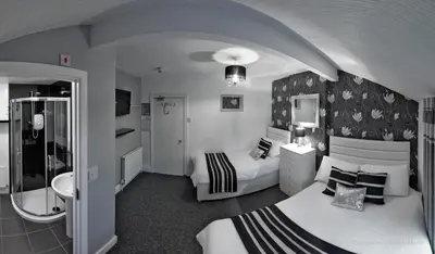 a hotel room with two beds and a bathroom at Ardern Hotel in Blackpool