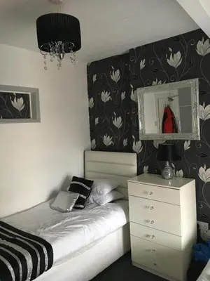 a bedroom with a bed with a dresser and a mirror at Ardern Hotel in Blackpool