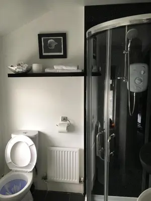 a bathroom with a toilet and a glass shower at Ardern Hotel in Blackpool