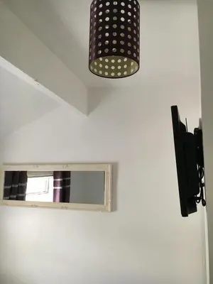 a bathroom with a mirror and a light on the wall at Ardern Hotel in Blackpool