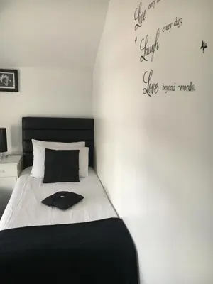 a bedroom with a bed with a black headboard at Ardern Hotel in Blackpool