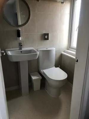a bathroom with a toilet and a sink and a mirror at The Fossil Tree Hotel in Blackpool