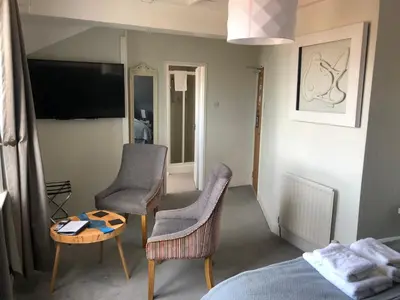 a bedroom with two chairs and a table and a bed at The Fossil Tree Hotel in Blackpool