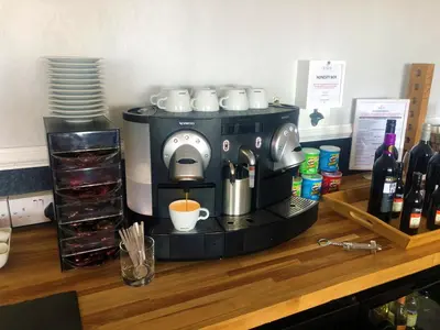a coffee maker sitting on a counter with wine bottles at The Fossil Tree Hotel in Blackpool