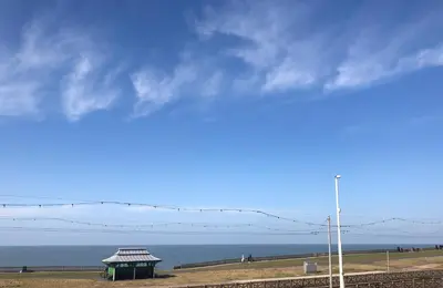 a building on the beach with the ocean in the background at The Fossil Tree Hotel in Blackpool