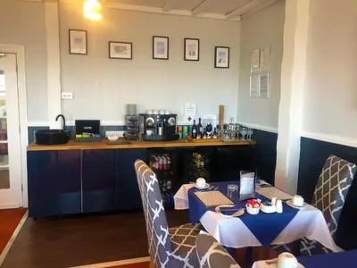 a table with a blue table cloth on it in a room at The Fossil Tree Hotel in Blackpool