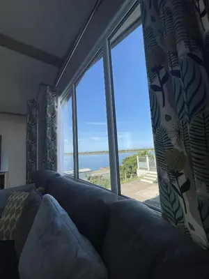 a living room with a couch and a view of the ocean at Lake View 92 in Millom