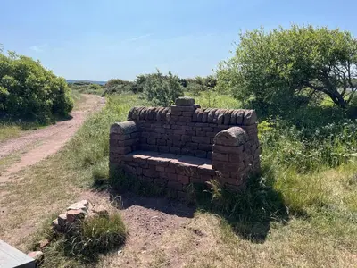 a brick wall sitting on the side of a dirt road at Lake View 92 in Millom