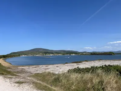 a beach with water and mountains in the background at Lake View 92 in Millom