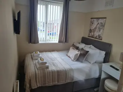 a small bedroom with a bed with towels on it at Crabtree House in Moreton