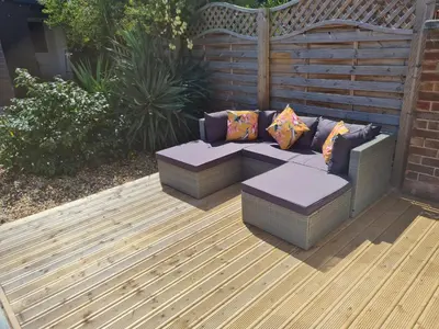 a patio with a couch and pillows on a deck at Crabtree House in Moreton