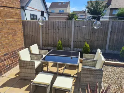 a patio with a table and chairs and a fence at Crabtree House in Moreton