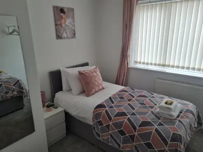 a small bedroom with a bed and a window at Crabtree House in Moreton