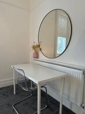 a white table with a mirror and a chair at Spacious Victorian Birkdale Apartment with Garden in Southport