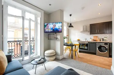 a living room with a couch and a tv on a wall at Preston Apartments in Preston