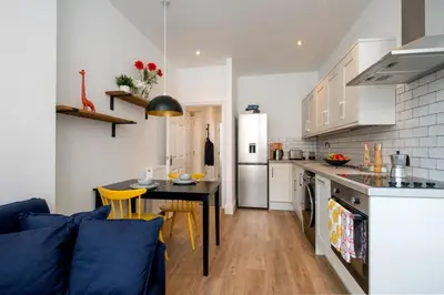 a kitchen and living room with a table and chairs at Preston Apartments in Preston