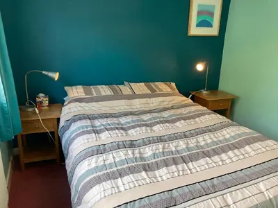 a bedroom with a bed and a desk with a lamp at Fairways in Cleveleys