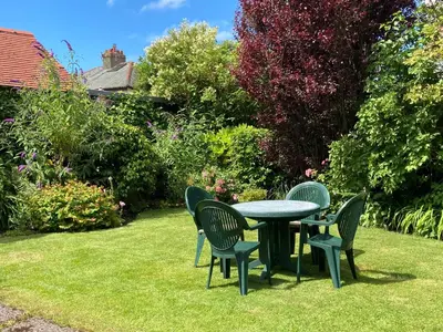 a table and chairs on the grass in a garden at Fairways in Cleveleys