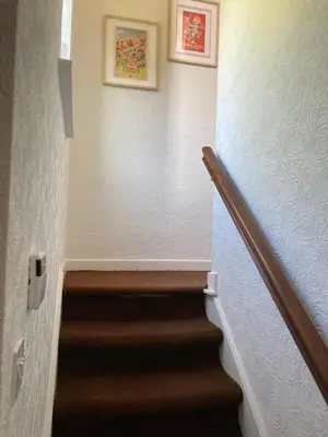 a hallway with a staircase with two pictures on the wall at Fairways in Cleveleys