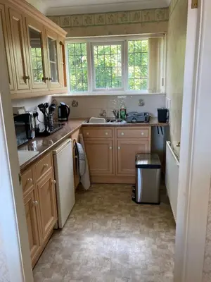a kitchen with wooden cabinets and a sink at Fairways in Cleveleys