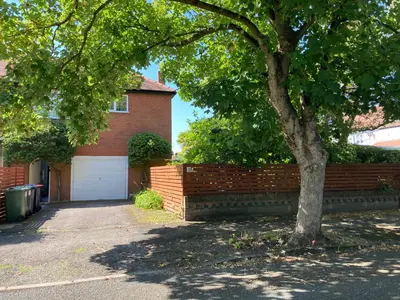 a house with a brick fence and a tree at Fairways in Cleveleys