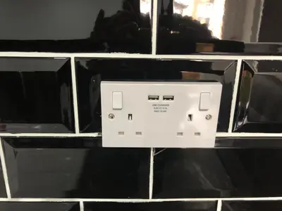 a white microwave on a wall with black tiles at Ground Floor Apartment 2, Lynton Apartments in Blackpool