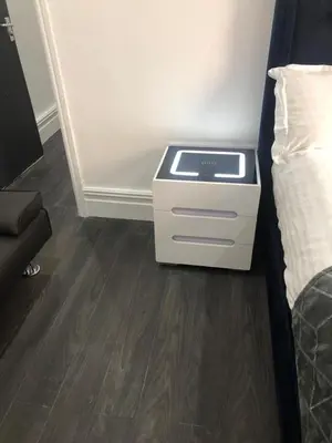 a bed room with a night stand next to a bed at Ground Floor Apartment 2, Lynton Apartments in Blackpool