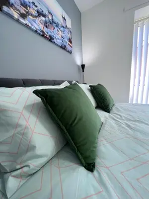 a bed with green pillows on it in a bedroom at Marina Princes Reach 2 in Penwortham