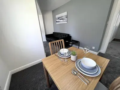 a wooden table with plates and wine glasses on it at Marina Princes Reach 2 in Penwortham