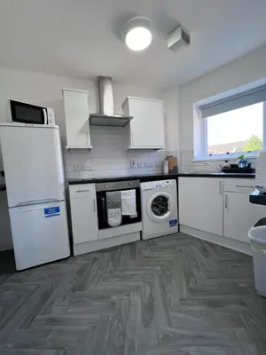 a kitchen with white appliances and a wooden floor at Marina Princes Reach 2 in Penwortham