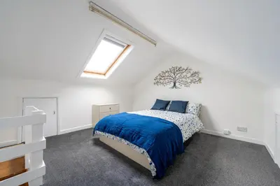 a bedroom with a bed with a blue comforter at Luxury Liverpool Accommodation in Liverpool