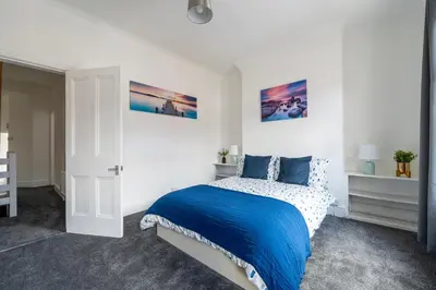 a bedroom with a bed with a blue blanket at Luxury Liverpool Accommodation in Liverpool