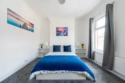 a white bedroom with a blue bed in it at Luxury Liverpool Accommodation in Liverpool